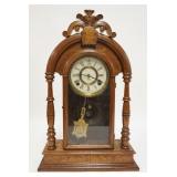 1089	CARVED WALNUT GINGERBREAD CLOCK, HAS FULL TURNED COLUMNS & AN OLD STORE LABEL BARGAIN BARN NEPT