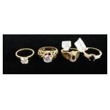 1073	LOT OF FOUR RINGS TWO OF THE RINGS HAVE RHINESTONES & TWO HAVE SAPPHIRE STONES. 