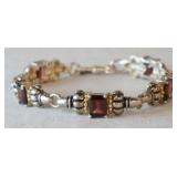 1112	BEAUTIFUL STERLING SILVER BRACELET W/ 14K GOLD ACCENTS & RED GEMSTONES. IT APP. 7 1/4 IN L . AL