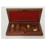 1194	5 PERFUMES IN A WOODEN BOX, ONE IS HERMES, TALLEST BOTTLE IS 2 1/2 IN