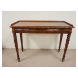 1038	WALNUT 3 DRAWER LOCKING WRITING TABLE WITH TURNNED TAPERED FLUTED LEGS AND A FLAMED WALNUT TOP.