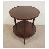 1059	2 TIER ROUND MAHOGANY LAMP TABLE, BOOK MATCHED VENEER TOP. DAMAGE TO SECTION OF TOP TRIM, 24 IN