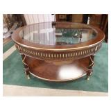 1129	EJ VICTOR GLASS TOP COFFEE TABLE, HAS BRASS & GILT TRIM, 46 IN DIAMETER, 21 1/2 IN HIGH