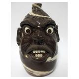 1160	MICHELLE PERDUE GROTESQUE FACE JUG, SWIRL FACE JUG, BROWN BASE WITH CREAM SWIRLS, SIGNED ON BOT