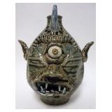 1164	GROTESQUE FACE JUG HAVING 1 HORN, 1 EYE AND OPEN MOUTH WITH EXPOSED TEETH. IMPRESSED SEA SHELLS