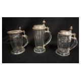 1168	3 ANTIQUE BLOWN GLASS STEINS W/ PEWTER LIDS. TWO HAVE ACORN FINIALS. APPLIED HANDLES. ONE HAS A