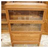 1176	SOLID OAK 3 SECTION BARRISTER BOOKCASE ONE BLIND DOOR. 34 IN WIDE, 11 IN DEEP, 49 IN H 