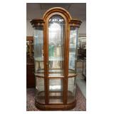 1083	CURVED GLASS CHINA CABINET HAS A CUT FRONT PANEL, MIRROR BACK , GLASS SHELVES, & ARCH TOP, 87 I