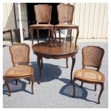 1191	ITALIAN WALNUT TABLE WITH 4 CANE CHAIRS, FINISH WORN AND CANE STRESSED ON SOME CHAIRS