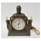 1180	METAL ROOSEVELT CLOCK TITLED *IN THE SPIRIT OF THE USA* 11 IN X 9 1/2 IN X 4 IN 