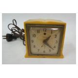 1183	TELECHRON BUTTERSCOTCH ALARM CLOCK HAS CRACK ON LOWER RIGHT. 4 1/2 IN H 