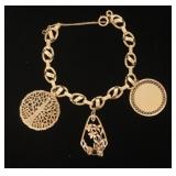 1186	14K CHARM BRACELET, WITH 3 CHARMS, FLORAL CHARM WITH RUBY OR GARNET STONE, NO VISABLE MARK. APP