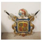 1309	CARVED WOODEN COAT OF ARMS, PAINTED, SWORDS ARE METAL, 34 IN HIGH X 35 IN WIDE