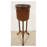 1121	OAK PLANT STAND, HAS A METAL LINER, FLUTED LEGS, ONE LEG REPAIRED, 10 IN DIAMETER X 31 1/2 IN H