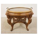 1124	HEAVILY CARVED TRAY TOP TABLE, HAS FACES ON THE CORNERS & A CARVED SCENE UNDER THE GLASS, 24 IN