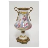 1046	SEVRES HAND PAINTED BOLTED URN W/BRASS MOUNTS, LADY & CHERUB W/SCENEIC REVERSE, 10 3/4 IN HIGH