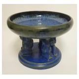 1069	FULPER COMPOTE W/ 3 CROUCHING FIGURES AT THE BASE 10 1/4 IN DIAMETER, 7 3/8 IN H 