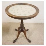 1141	SNAKE FOOT GLASS TOP CANDLE STAND HAS FABRIC UNDER THE GLASS. 14 5/8 IN DIAMETER 20 1/4 IN H 