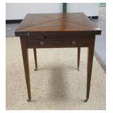 1306	HANDKERCHIEF GAME TABLE, LEATHER SURFACE, HAS ONE DRAWER, WOODEN TOP IS SCRATCHED, OPEN 34 IN S
