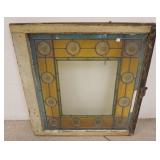 1062	STAINED GLASS WINDOW W/ BULLSEYE HAVING A SWIRL PATTERN. ONE BLUE THIN PANEL ON THE TOP SIDE IS