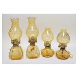 1117	4 AMBER FOSTORIA COIN GLASS OIL LAMPS, TWO ARE CHAMBER LAMPS. TALLEST 14 IN H 