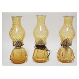 1299	3 FOSTORIA COIN AMBER LAMPS W/OPALESCENT THUMBPRINT CHIMNIES, ONE IS ELECTRIC, PLUG CUT