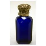 1012	COBALT BLUE GLASS CUT & POLISHED BOTTLE W/ORNATE VICTORIAN METAL HINGED LID, APPROXIMATELY 3 1/
