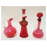 1192	GROUP OF 3 CRANBERRY DECANTERS, TALLEST APPROXIMATELY 12 IN HIGH