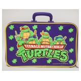 1182	VINTAGE 1989 TEENAGE MUTANT NINJA TURTLES SUITCASE & CONTENTS. SUITCASE APP. 17 IN X 10 1/2 IN 