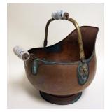 1122	COPPER SKUTTLE BUCKET	COPPER SKUTTLE BUCKET WITH PORCELAIN HANDLES AND EMBOSSED LION HEADS, APP