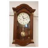 1153	HOWARD MILLER WALL CLOCK IN CHERRY CASE, APPROXIMATELY 7 IN X 13 IN X 25 IN HIGH