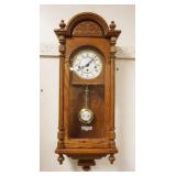 1156	HOWARD MILLER KEY WOUND WALL CLOCK IN SOLID OAK CASE, APPROXIMATELY 6 IN X 12 IN X 32 IN HIGH