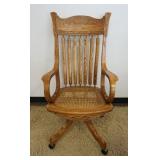 1180	SOLID OAK PRESSED BACK SWIVEL DESK CHAIR, CANE SEAT