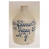 BLUE SCRIPT DECORATED STONEWARE JUG, MAX STINER & CO NY, CHIP ON TOP SPOUT, APPROXIMATELY 9 1/4 IN HIGH