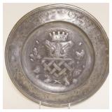 1115	PEWTER CHARGER W/EMBOSSED CREST DESIGN IN CENTER, APPROXIMATELY 13 IN