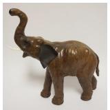 1039	LEATHER ELEPHANT MISSING ONE TUSK, APPROXIMATELY 14 IN X 6 IN X 14 IN HIGH