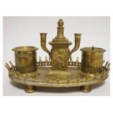 1067	ANTIQUE BRASS INKWELL W/EMBOSSED CHERUBS AT CENTER, MISSING GLASS INSERT, APPROXIMATELY 9 IN X 