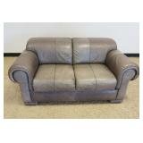 1107	GREY LEATHER LOVESEAT, SOME STAINING IN FRONT, APPROXIMATELY 39 IN X 63 IN X 29 IN HIGH
