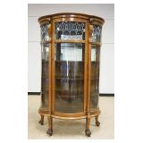 1118	OAK CHINA CABINET, CURVED GLASS, BOW FRONT W/CARVED LION HEADS & LEADED GLASS TOP & 4 ADJUSTABL