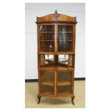 1152	OAK CURVED GLASS CURIO CORNER CABINET, 4 DOOR W/BEVELED MIRROR CENTER, 3 AJUSTALBE SHELVES, APPROXIMATELY 26 IN X 34 IN X 84 IN HIGH