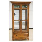 1181	PULASKI OAK 2 DOOR CRYSTAL CABINET WITH LOWER DRAWER AND BEVELED GLASS DOORS WITH SLAG AND ICED GLASS TOP, ADJUSTABLE SHELVES WITH INTERIOR LIGHTS, APPROXIMATELY 42 IN X 17 IN X 84 IN H