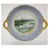 1033	JP LIMOGES FRANCE HAND PAINTED PLATE, DOUBLED HANDLED W/SWANS IN WATER ALONG FIELD W/GILT EDGE,
