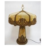ORNATE ANTIQUE SLAG GLASS TABLE LAMP, METAL IMAGES OF WINGED GRIFFINS & WOMAN BUST, INTERIOR LIT SLAG GLASS BASE, CURVED SLAG GLASS PANELS ON SHADE, APPROXIMATELY 18 IN X 26 IN HIGH