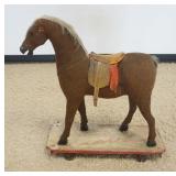 1112	ANTIQUE CHILDS HORSE ON WOOD BASE WITH CAST METAL WHEELS, APPROXIMATELY 26 IN X 12 IN X 31 IN H