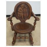 1264	CARVED OAK ROCKER WITH IMAGE OF A MAN PLAYING CELLO, APPROXIMATELY 25 N X 32 IN X 34 IN H