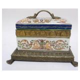 1147	CONTEMPORARY PORCELAIN COVERED BOX IN ORNATE METAL CLAW FOOT BASE, APPROXIMATELY 12 X 8 IN X 9 