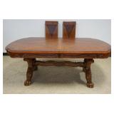 1255	OAK DINING TABLE WITH BOOK MATCHED VENEER TOP, CARVED SKIRT, CARVED PAW FEET WITH GILT ACCENTS,