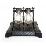 1003	ANTIQUE DOUBLE INKWELL W/REVOLVING GLASS WELLS IN CAST METAL BASE, APPROXIMATELY 7 IN X 4 1/2 I