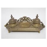 1005	ORNATE CAST BRASS DOUBLE INKWELL W/HINGED LIDS, ONE HINGE PIN MISSING, APPROXIMATELY 11 IN X 5 