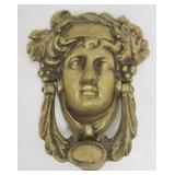 1010	NEOCLASSICAL IMAGE ON BRASS CAST DOOR KNOCKER, APPROXIMATELY 7 IN X 6 IN